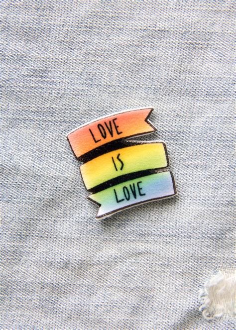 support lgbt rights with this colorful lapel pin it features a rainbow banner with the quote