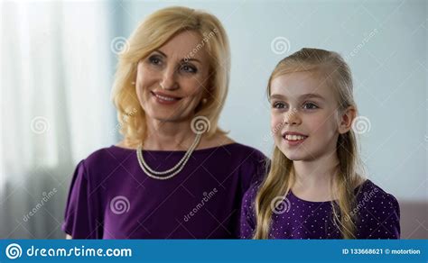 mooie kleindochter en haar oma die voor spiegel glimlachen