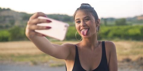 portrait of teenage girl taking selfie with smartphone