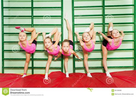Girls Training Gymnastics Near Wall Mounted Ladder Stock
