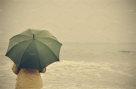 Woman With Green Umbrella On The Beach On A Rainy Day People Images