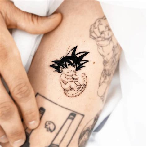 son goku tattoo located   upper arm cartoon