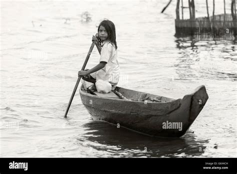 girl poling a dugout canoe bw tahas river kampong phluck cambodia