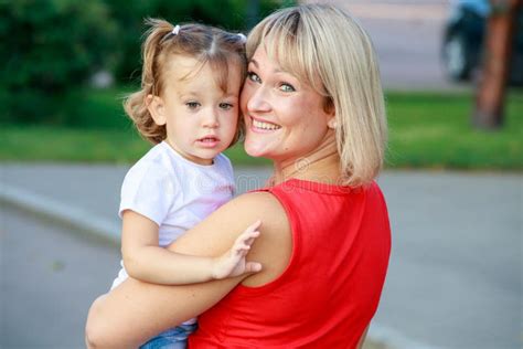 Beautiful Blonde Mom In A Red T Shirt With Her Daughter Group Portrait