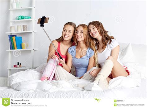 teen girls with smartphone taking selfie at home stock