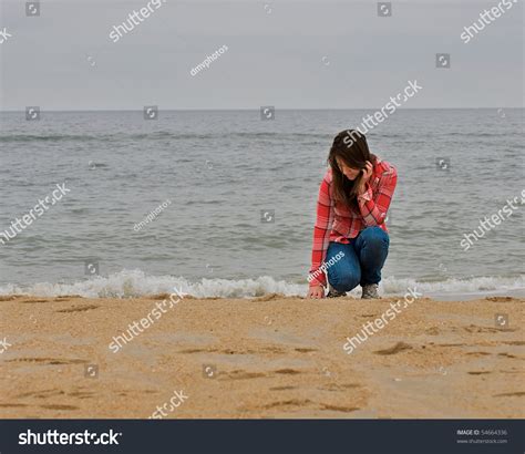 Стоковая фотография 54664336 teen girl kneeling sand on beach