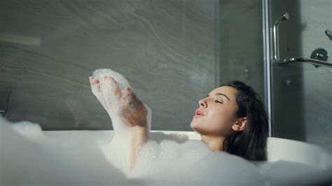 portrait of smiling woman taking bubble bath in modern interior