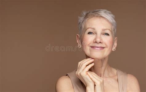beauty portrait of mature woman smiling with hand on face stock image