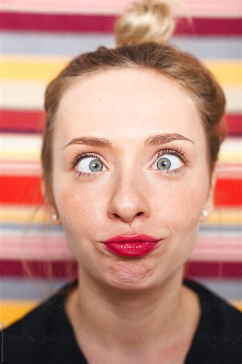 Blonde Woman Making Funny Faces In Front Of A Striped Wall By