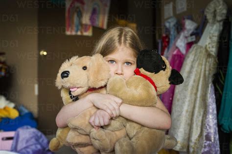 girl holding stuffed toys  bedroom  home stock photo