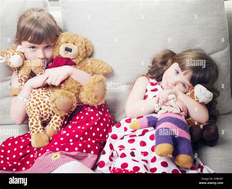 girls holding stuffed animals  sofa stock photo alamy