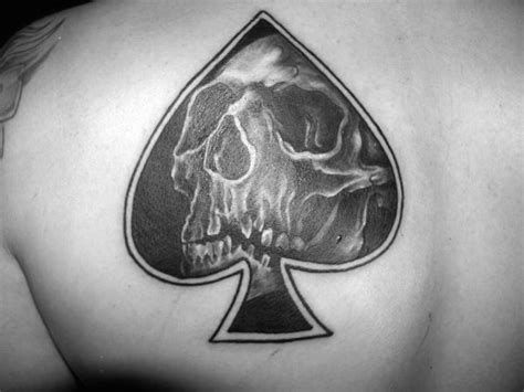 little black ink spades symbol stylized with skull tattoo on shoulder