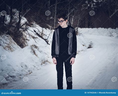 teen boy standing   snow covered road stock photo image