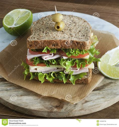 double sandwich with ham cheese lettuce tomato and green olives whole grain bread snack or
