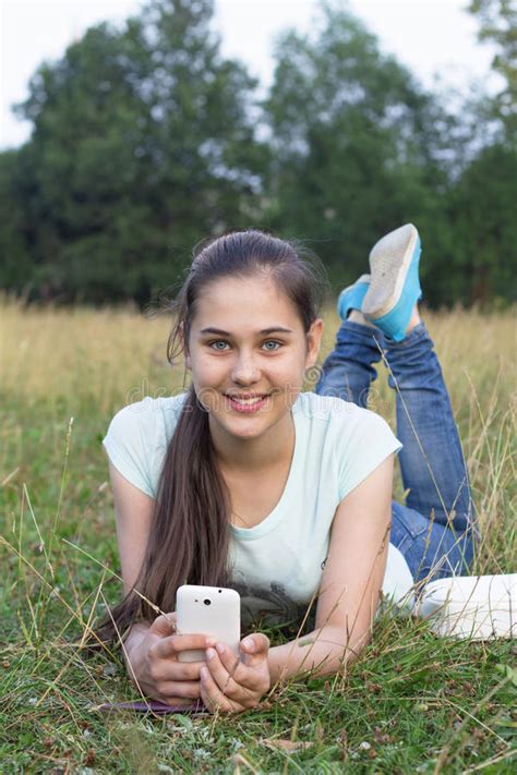 chica joven 12 14 años llying abajo de usar el smartphone foto de archivo imagen de hembra
