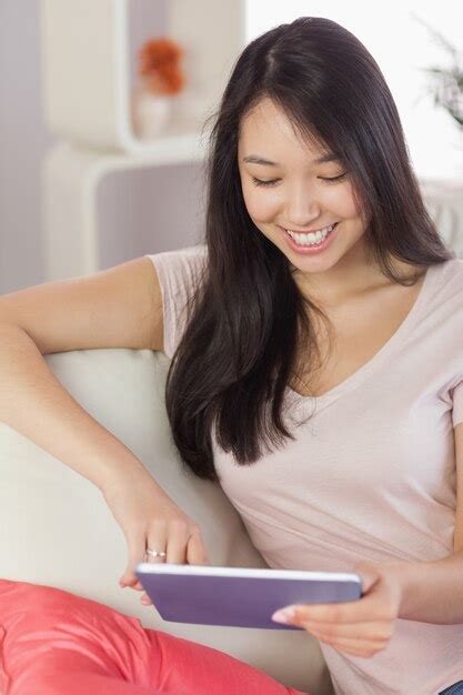 Premium Photo Pretty Asian Girl Using Her Tablet On The Couch