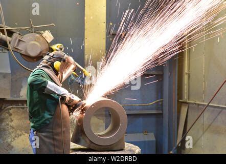 arbeiter schneiden stahl mit schleifmaschine und spritzer von sparks