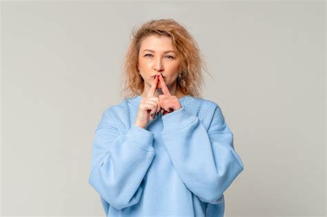 Modern Mature Woman With Curly Blonde Hair Showing Shhh Secret Hush