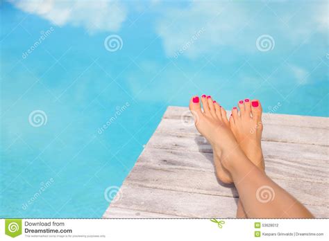 Bare Woman Feet On Wooden Deck By The Swimming Pool Stock