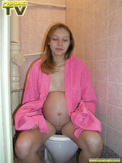 luscious pregnant teen takes her seat in the toilet and lets out a steaming golden piss from her