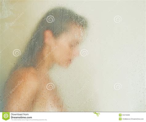 woman washing behind weeping glass shower door stock image image of