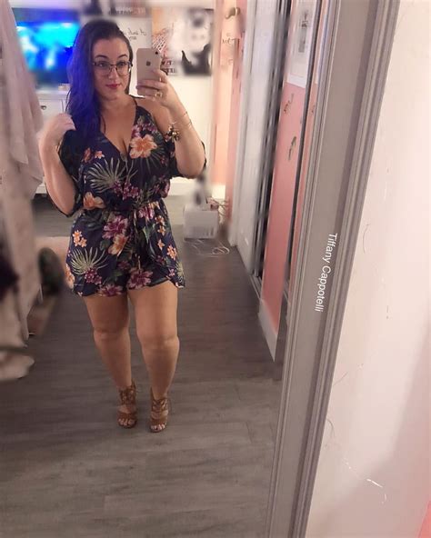 A Woman Is Taking A Selfie In The Mirror While Wearing A Floral Romper