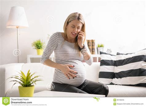Pregnant Woman In Labor Calling Hospital Stock Image