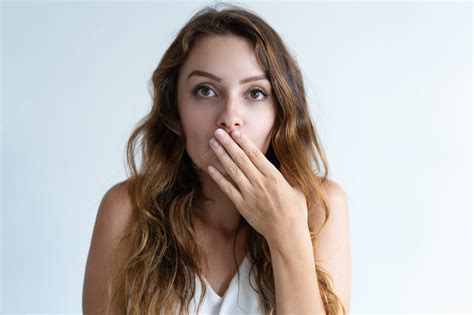Free Photo Embarrassed Pretty Young Woman Covering Mouth With Hand