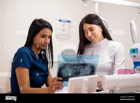 Young Female Doctor Reviewing X Ray Exams With Her Patient Inside A
