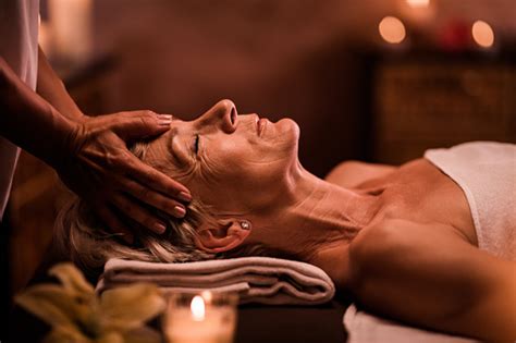 Senior Woman Having Head Massage By Unrecognizable Therapist At The Spa