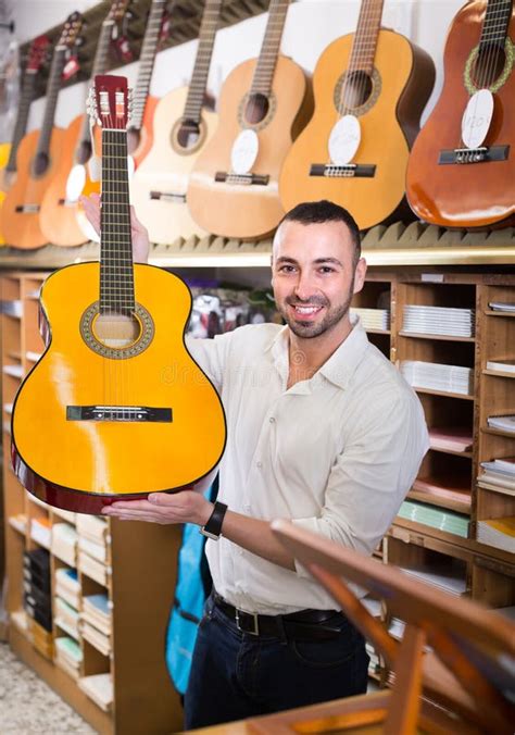 guy choosing guitar   shop stock photo image  assistant casual