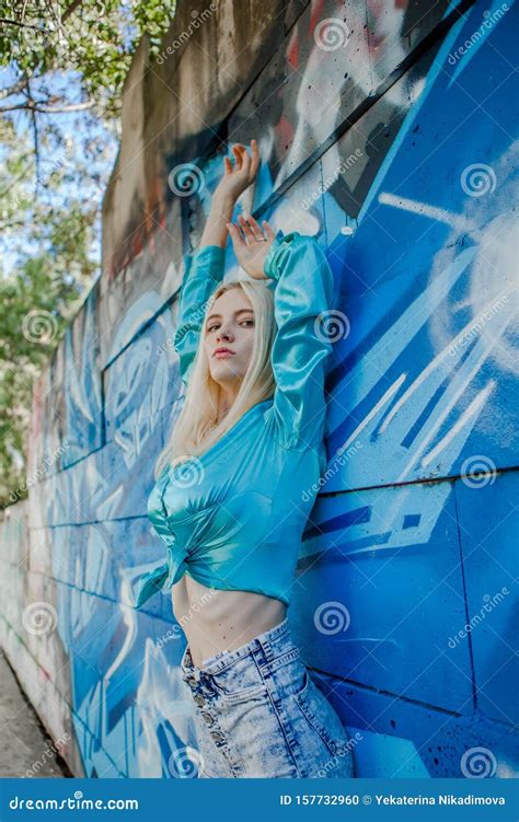 Young Girl Blonde Poses On A Background Of A Wall With Graffiti Stock