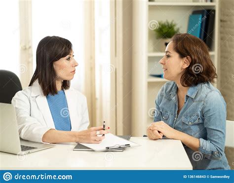 Female Specialist Doctor Listening To Woman Patient