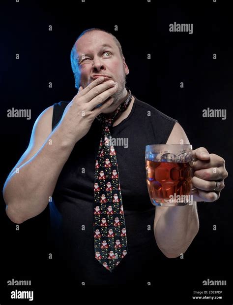 Comic Actor Man In Cap With Braids With A Glass Of Beer On A Black