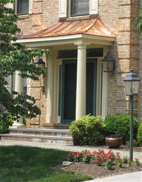 copper portico  tapered columns  stone patio windows  doors   porch roof