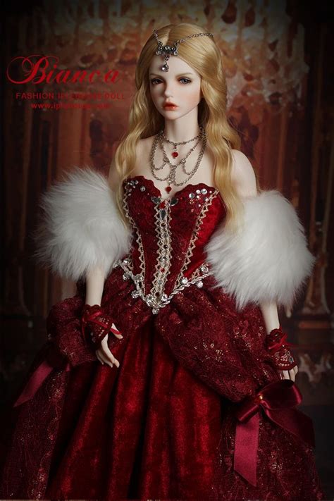 a barbie doll wearing a red dress with white furs and pearls on her head