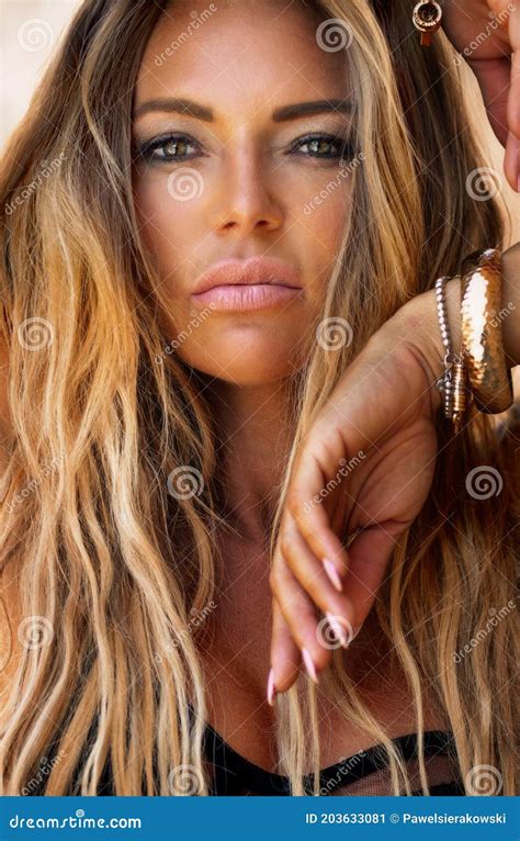 portrait of beautiful blonde woman with long hair and tanned body