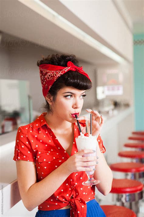 close up of rockabilly woman drinking milkshake at diner by audshule
