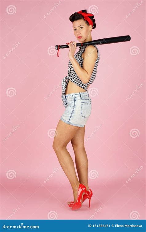 Beautiful Brunette Woman Stands And Holds A Black Baseball Bat On Her