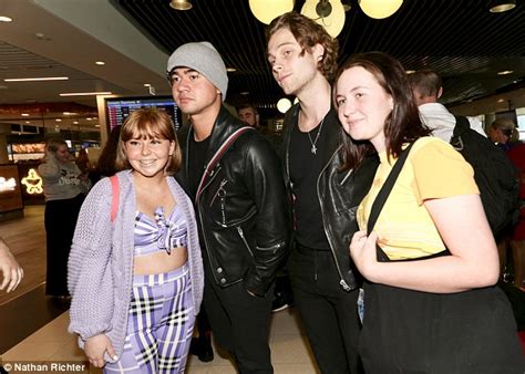 5sos star luke hemmings holds hands with raven haired stunner at brisbane airport daily mail