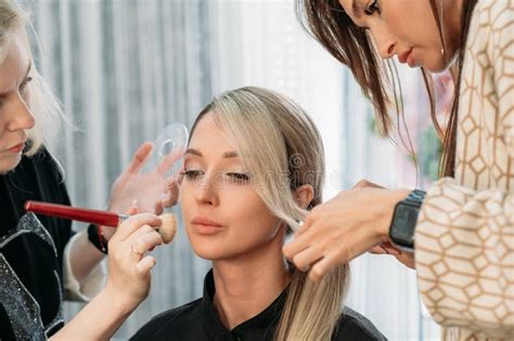 A Hairdresser And A Makeup Artist Together Prepare A Beautiful Model