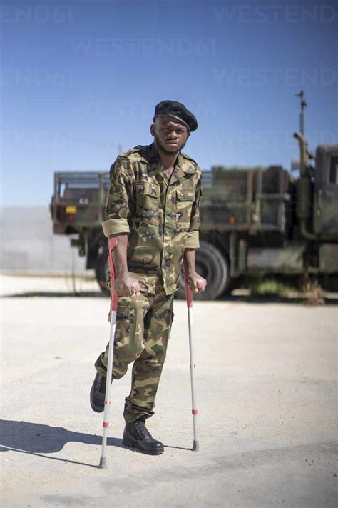 injured army soldier standing  crutches  sunny day stockphoto