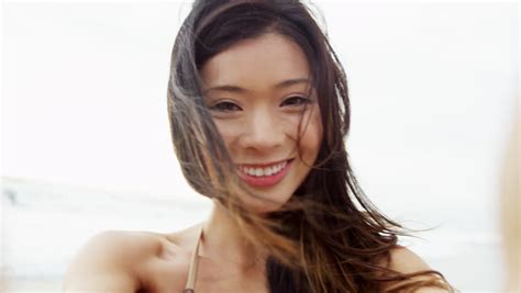 close up beautiful smiling asian chinese girl bikini outdoors beach vacation messaging friends