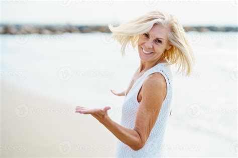 Happy Mature Woman Walking On The Beach Spending Her Leisure Time