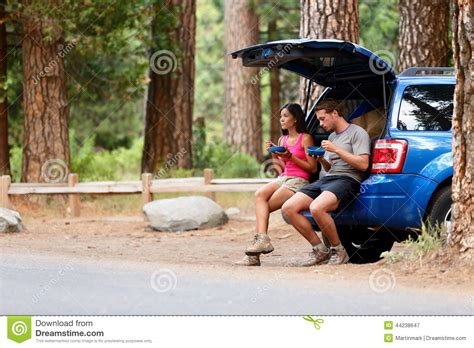 Couple On Car Road Trip Travel In Eating In Forest Stock