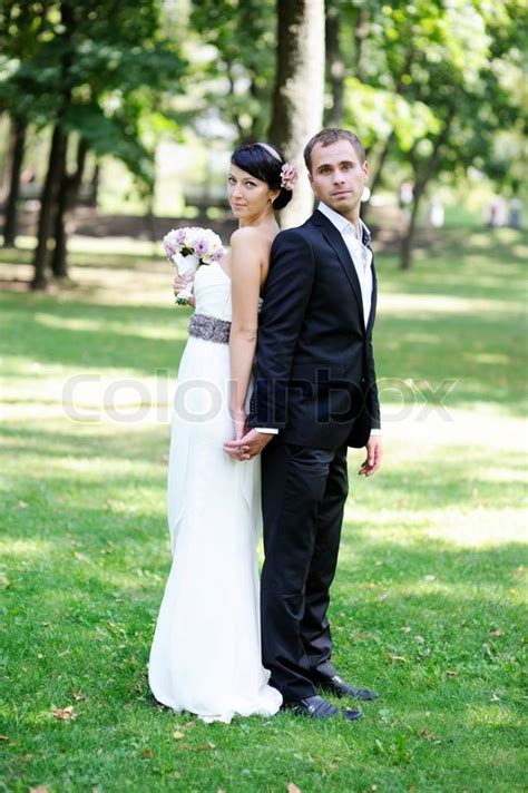 elegant bride and groom posing together outdoors on a