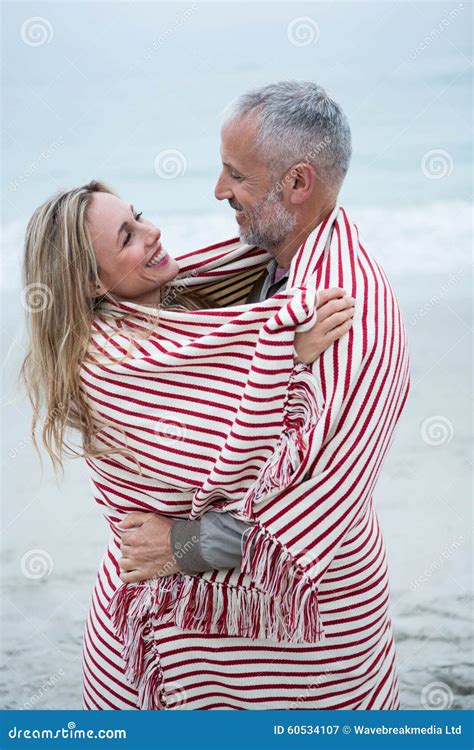 couple embracing  wrapped   beach towel stock image image