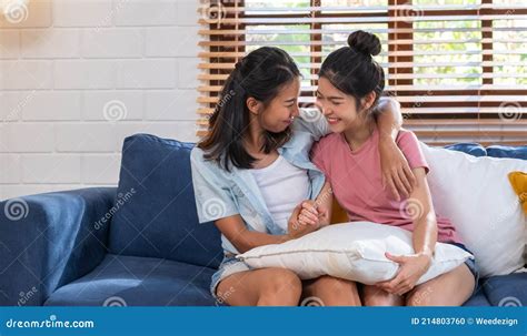Happy Asian Lesbian Couple Holding Hand And Hug Together At Sofa In