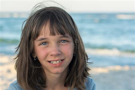 girl watching the waves from the shore of the sea with toy