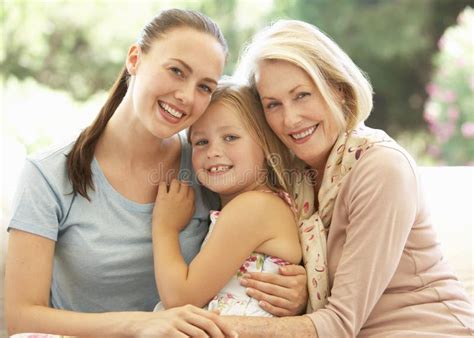 Grandmother With Daughter And Granddaughter Laughing Together On Sofa